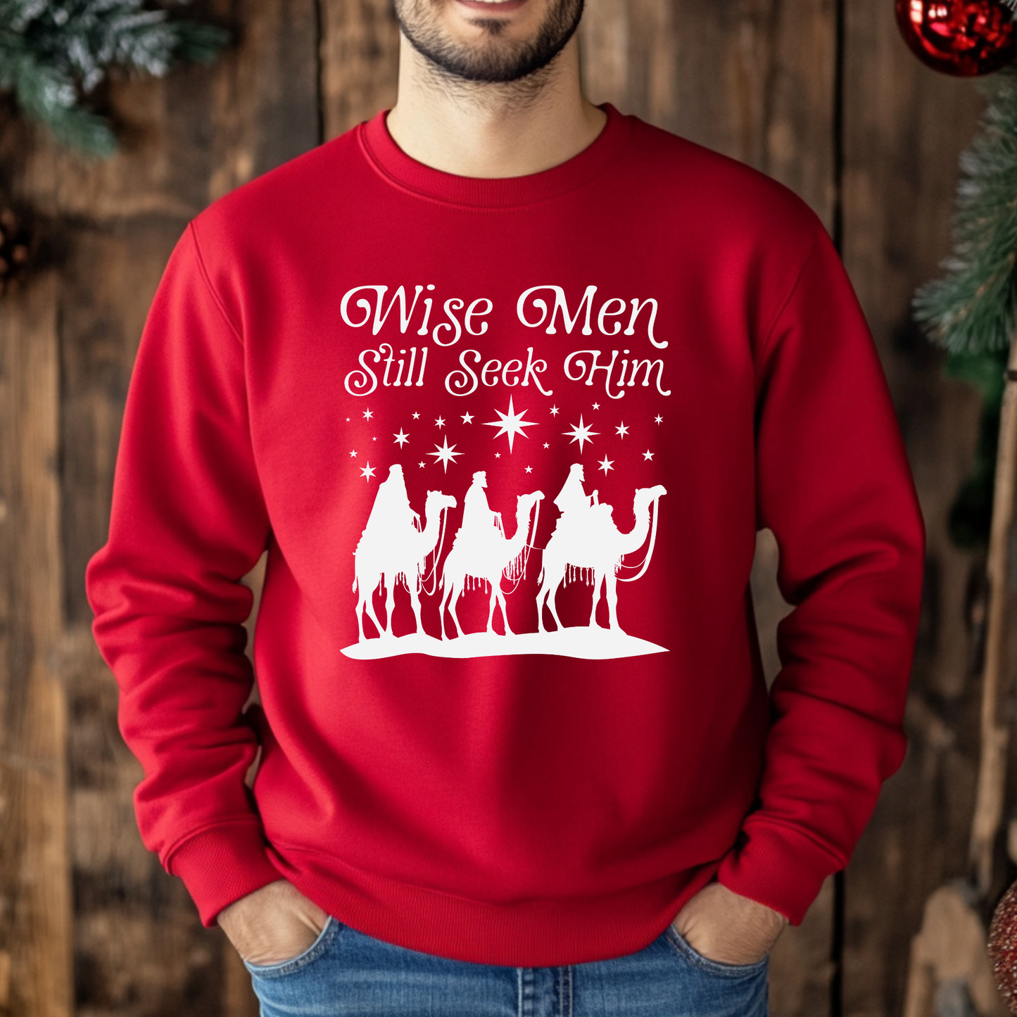 Red sweatshirt with 'Wise Men Still Seek Him' text and nativity scene graphic on a white background